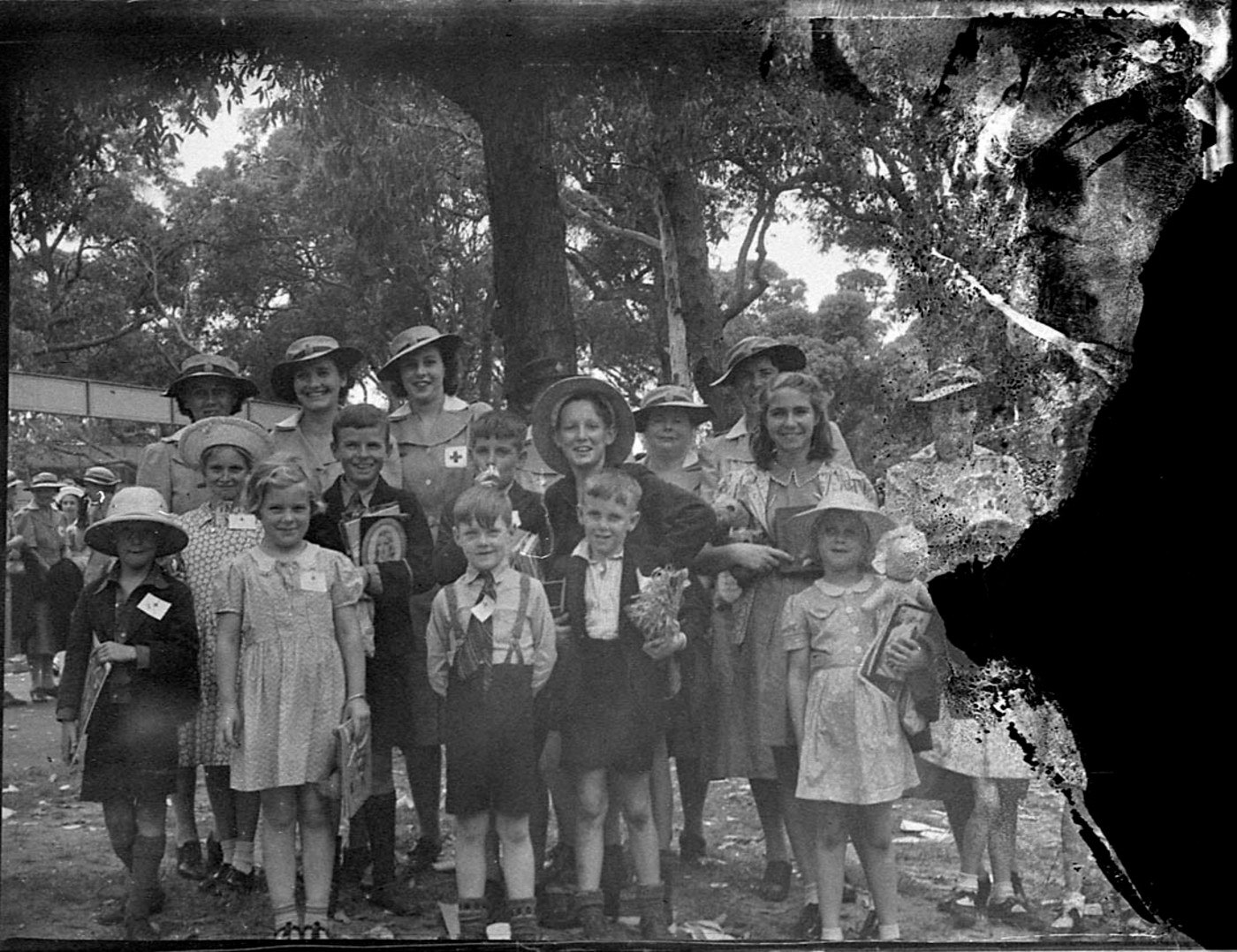 A photograph of a children's Christmas party with the whole right-hand side burned away to black